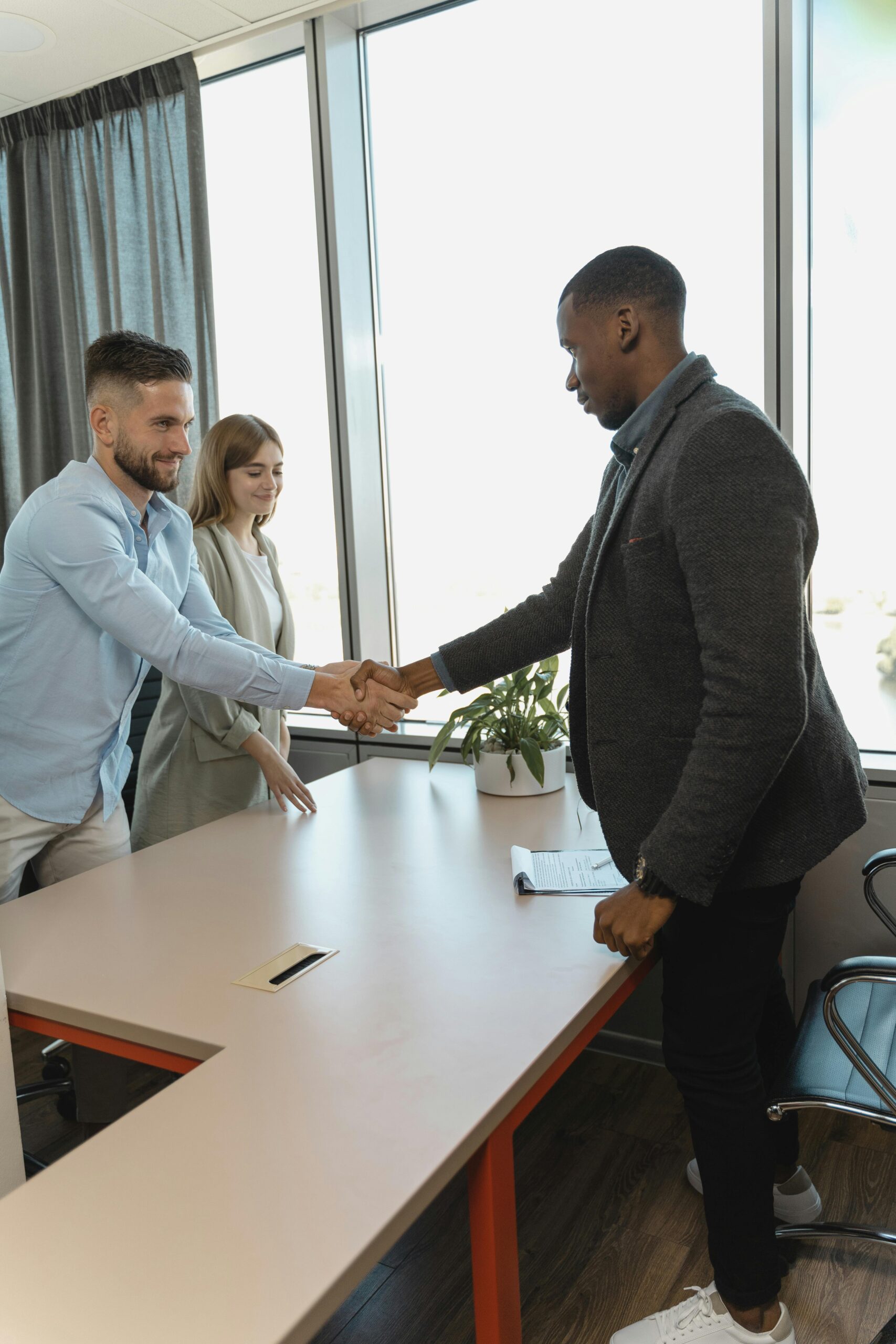 Professional handshake between colleagues in a modern office setting.